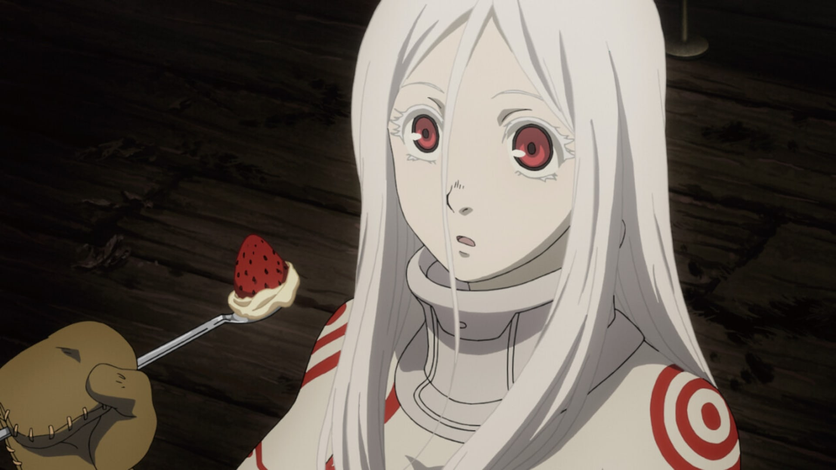 A white haired girl eats strawberry and cream in Deadman Wonderland