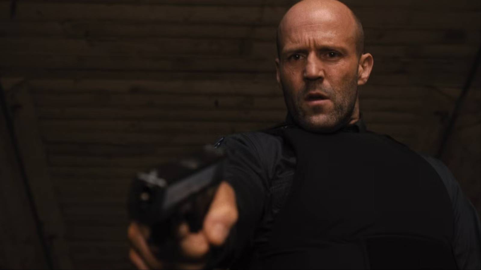 jason statham holding up a gun in wrath of man