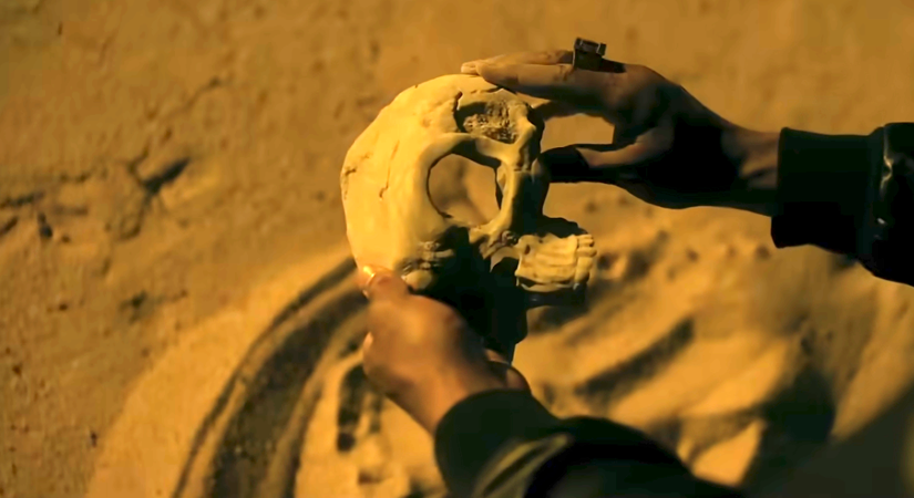 John Stewart (Aaron Pierre) holds a skull he picks up from the sand in Lanterns