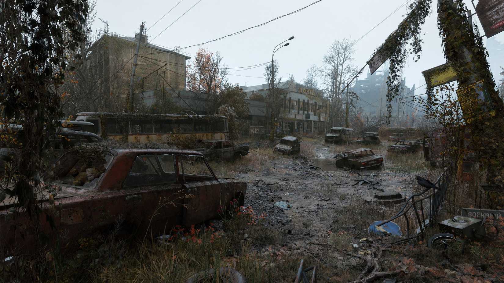 An exterior view of the Post Office environment, glimpsed across a muddy road strewn with ruined cars and busses.