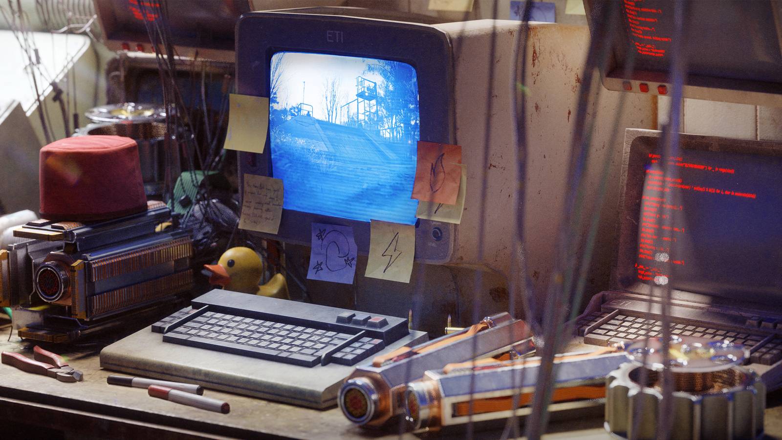 An old computer covered in post it notes on a desk littered with mechanical parts from Arc Raiders.