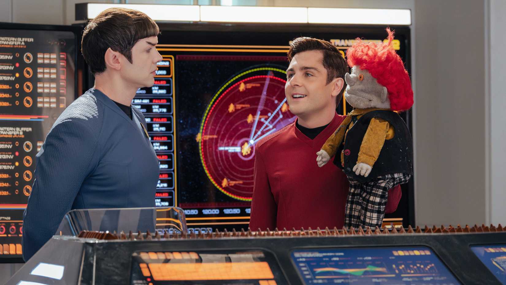 Spock looks at Scott who is holding a creepy puppet