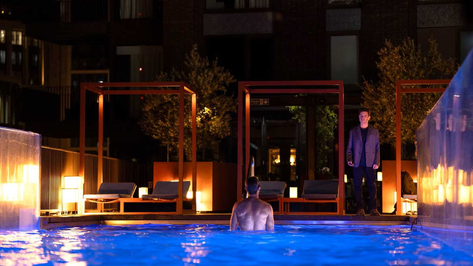 Rami Malek confronting another character in a pool in The Amateur.