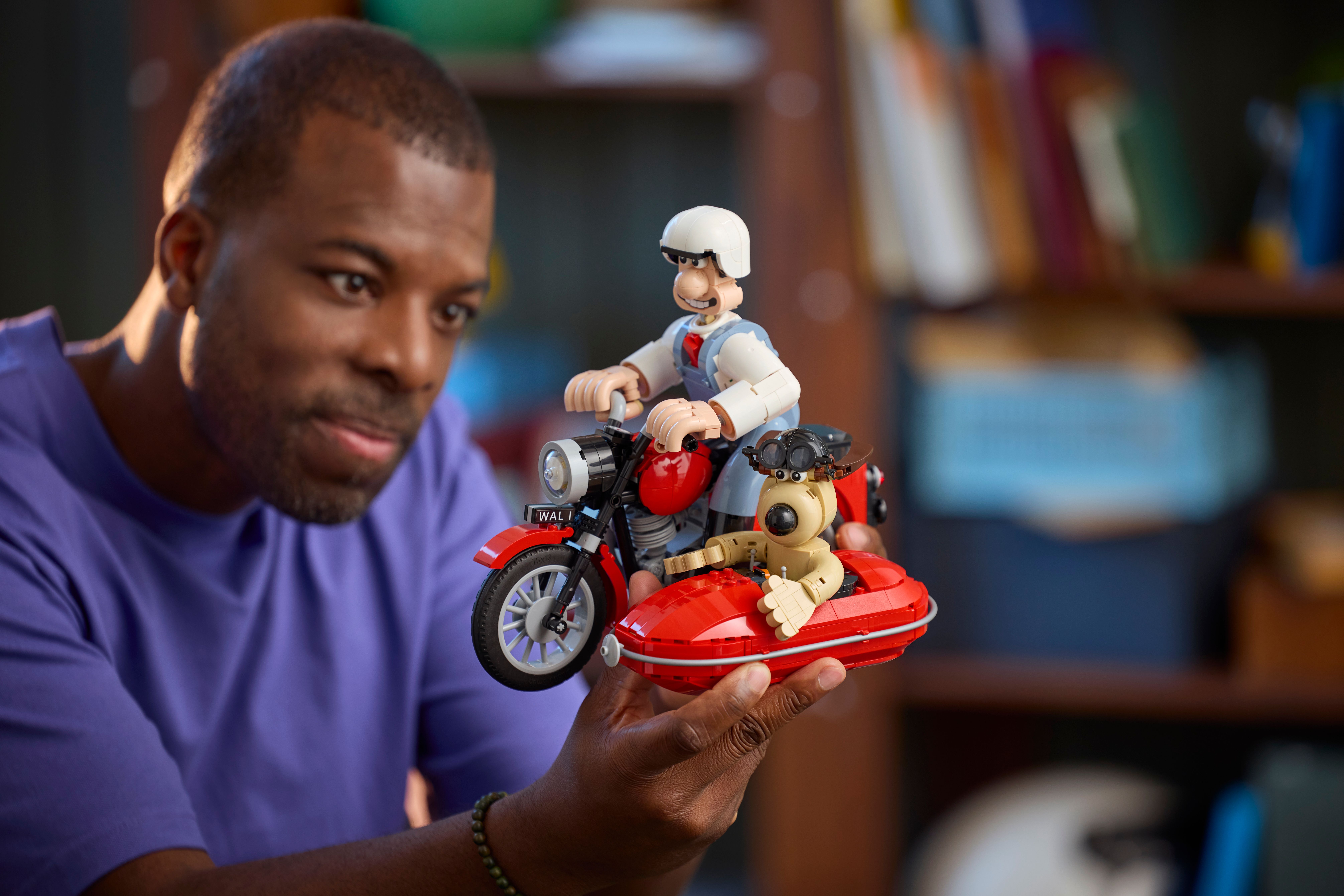 A man holding the Wallace and Gromit Set with one hand.