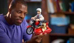 A man holding the Wallace and Gromit Set with one hand.