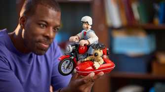 A man holding the Wallace and Gromit Set with one hand.