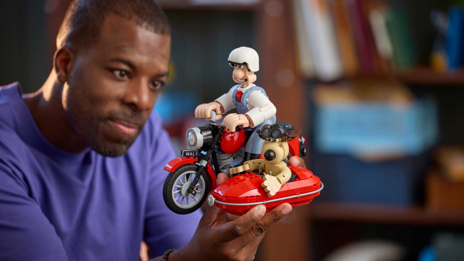 A man holding the Wallace and Gromit Set with one hand.