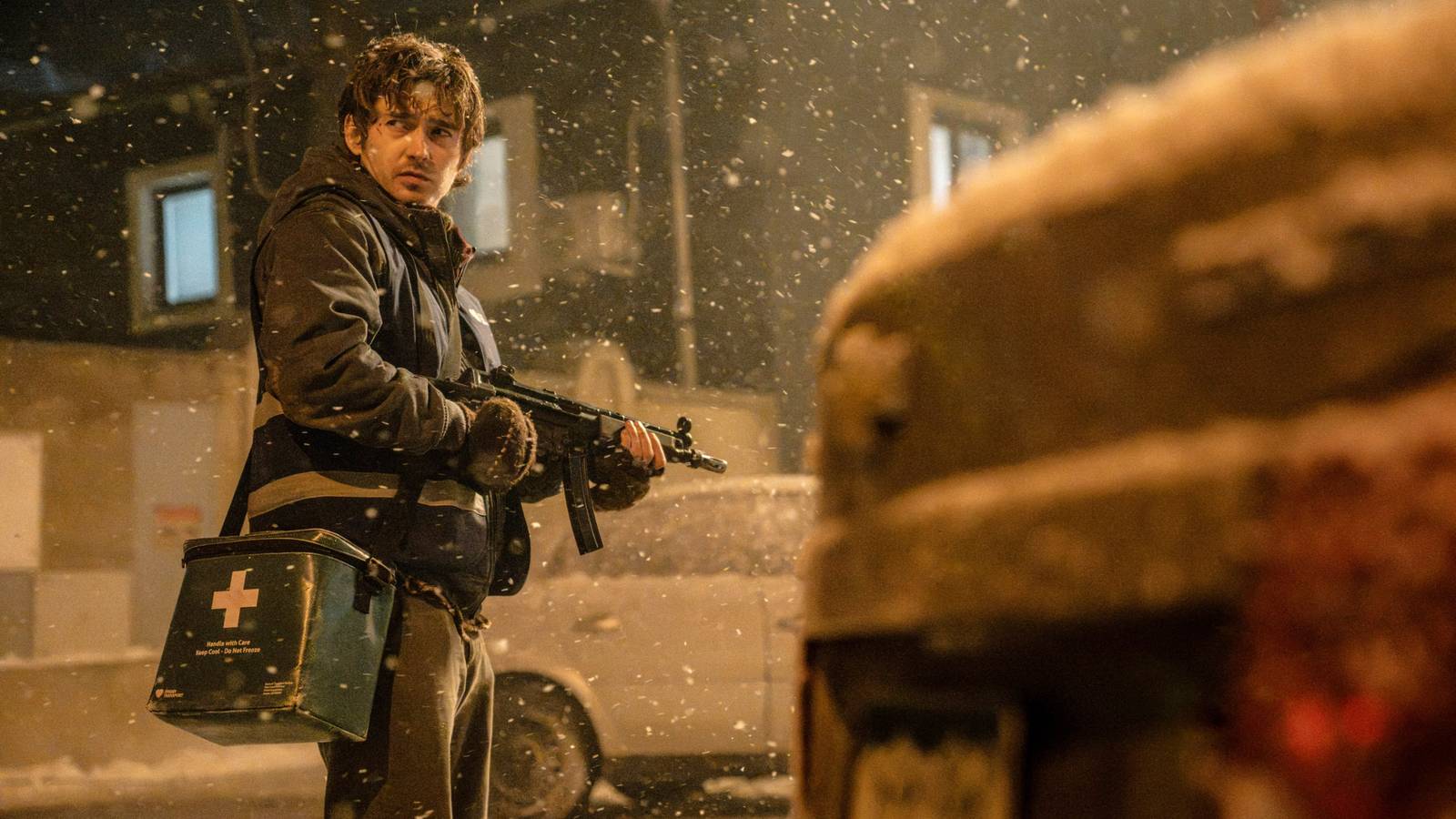 Image from Resident Evil showing Austin Abrams' holding a machine gun on a snowy street
