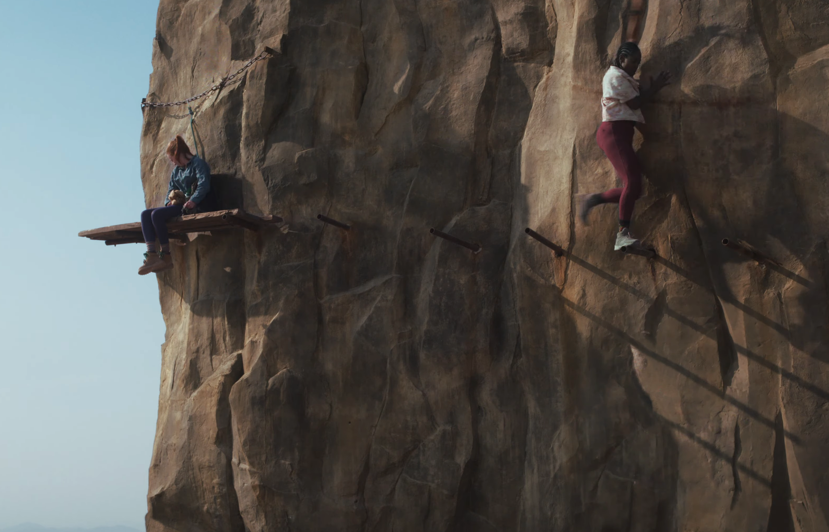 Two girls trying to climb a mountain in Fall 2