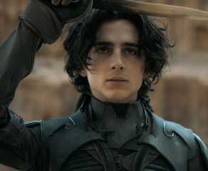 Timothée Chalamet salutes with a crysknife in the film Dune.