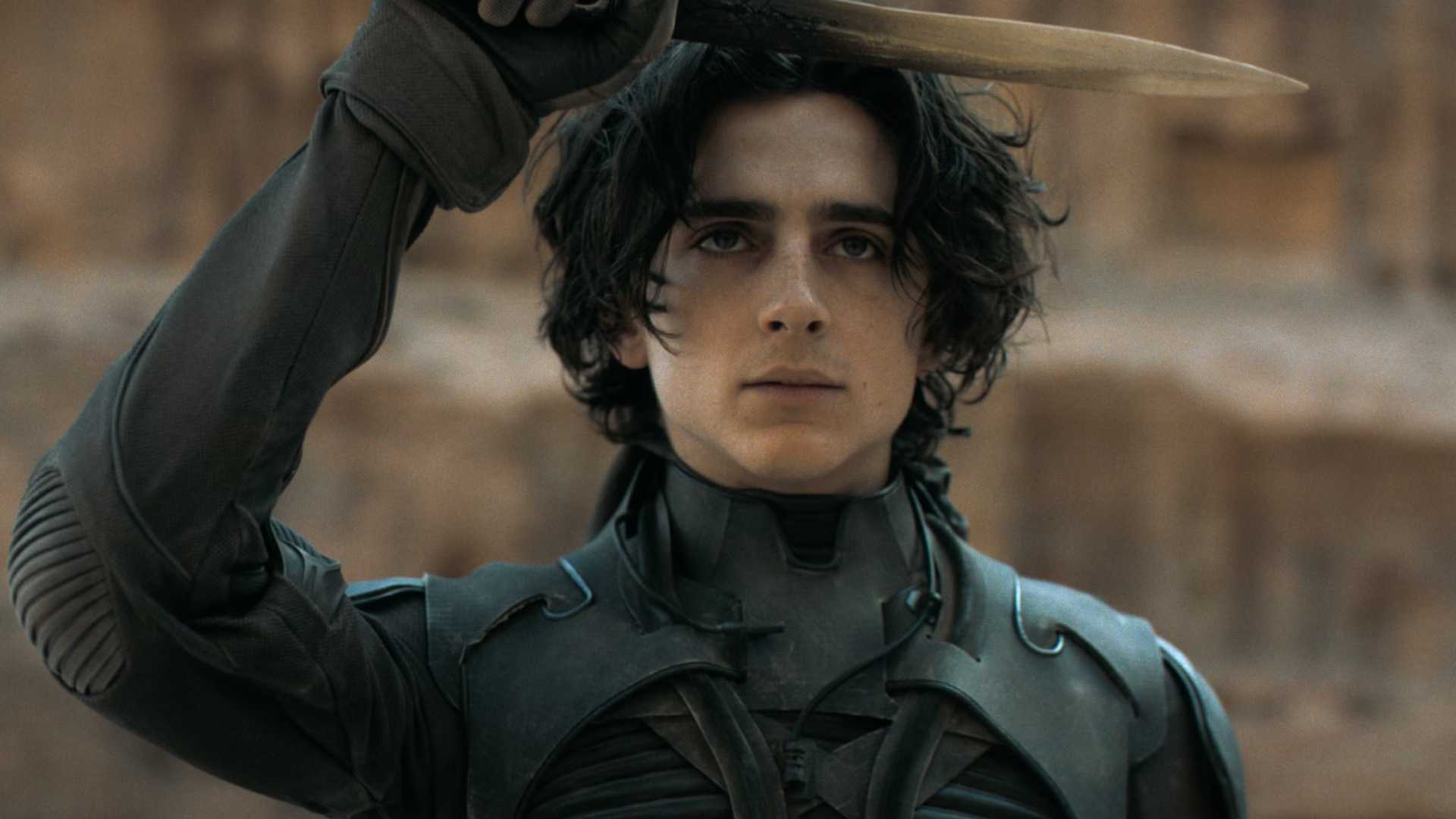 Timothée Chalamet salutes with a crysknife in the film Dune.