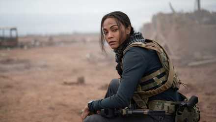 Zoe Saldaña sits in full combat gear on the edge of a battlefield in the Paramount Plus series Special Ops: Lioness.