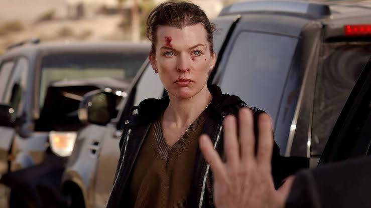 Milla Jovovich's Nikki Halstead stands near law enforcement officials