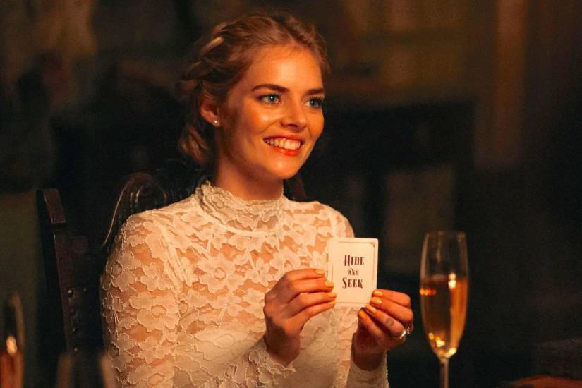 Grace holds up the Hide and Seek card in Ready or Not