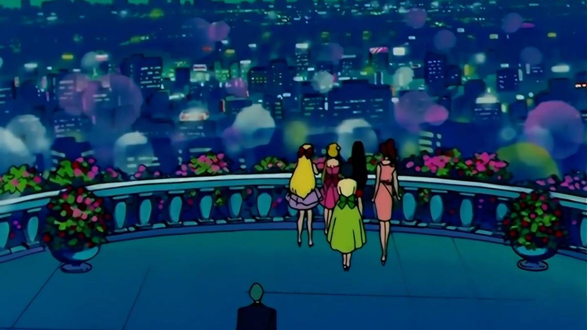 Sailor Moon and her friends with the city in the background
