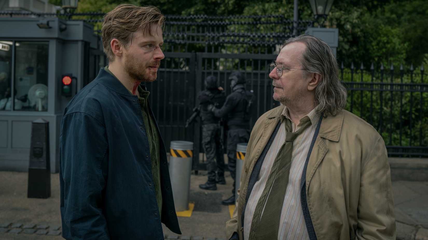 Jack Lowden and Gary Oldman talk in front of a secure area in Slow Horses