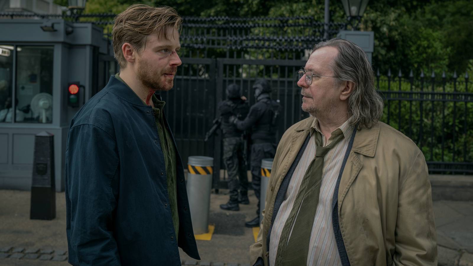 Jack Lowden and Gary Oldman talk in front of a secure area in Slow Horses