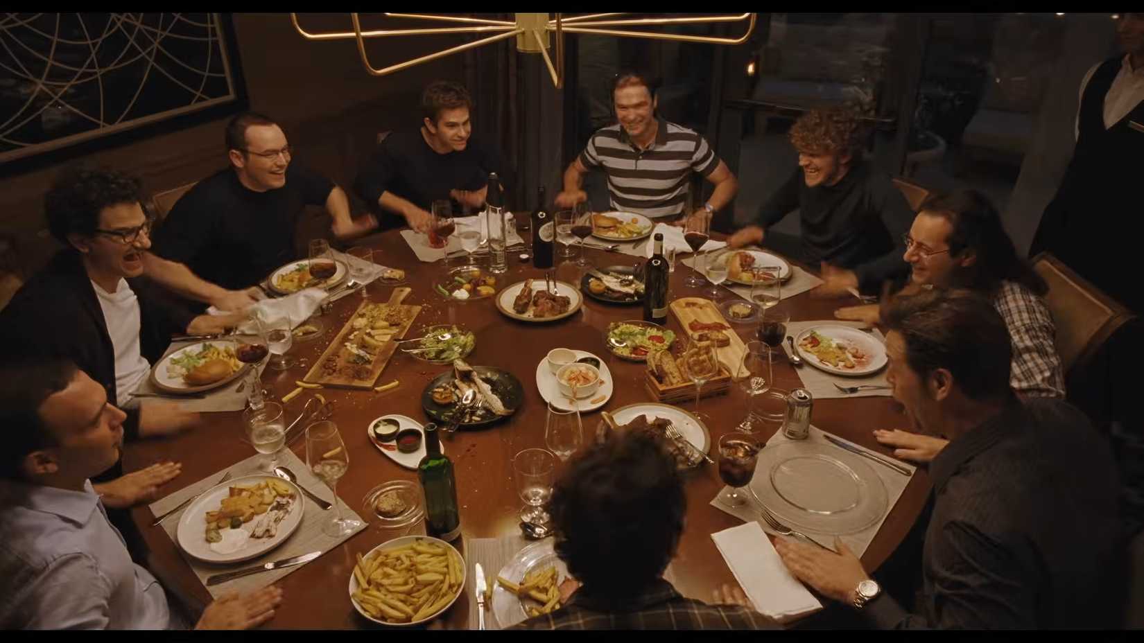 A bunch of men eating at a community table in Artificial