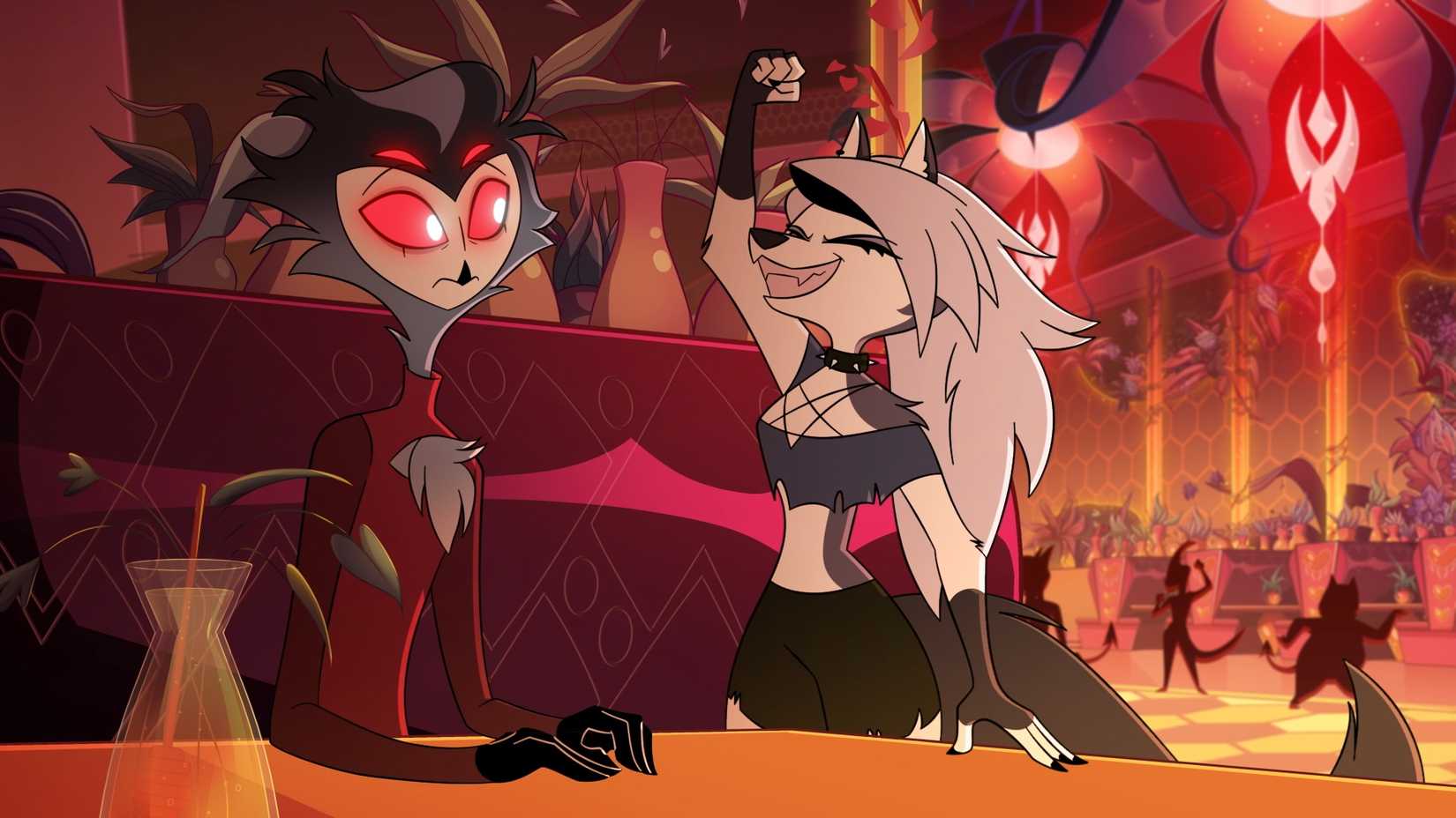 Stolas, a tall, thin owl-like demon, sits at a table in a nightclub with Loona, a humanoid hellhound who's grinning and raising an excited fist, in the animated series Helluva Boss