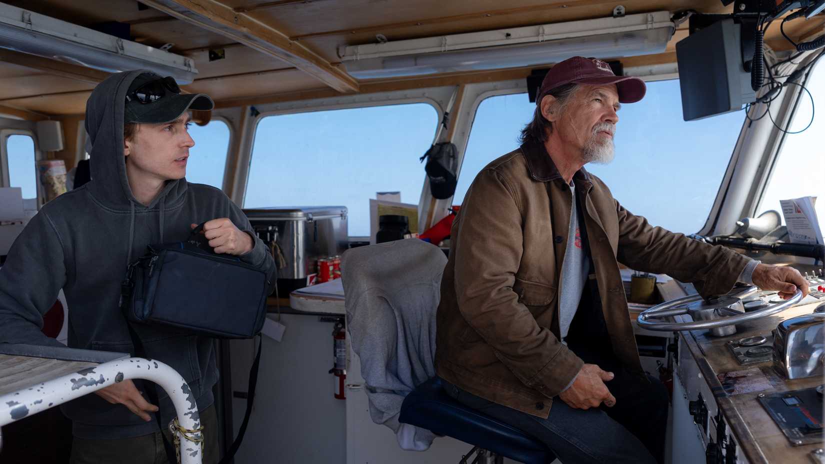 Jay (Austin Abrams) and Mitt (Josh Brolin) sit in the cockpit of a boat in Whalefall