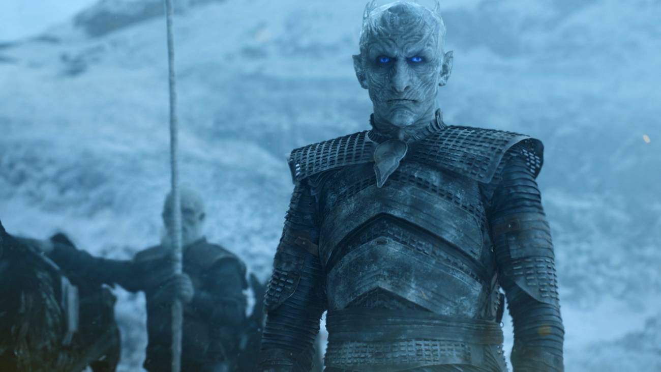 The Night King in Game of Thrones season 7, standing against a snowy backdrop with one of his White Walker soldiers behind him holding a spear