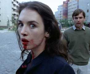 Isabelle Adjani with blood coming out of her mouth, and Sam Neill standing behind her, both looking distressed, in Possession.