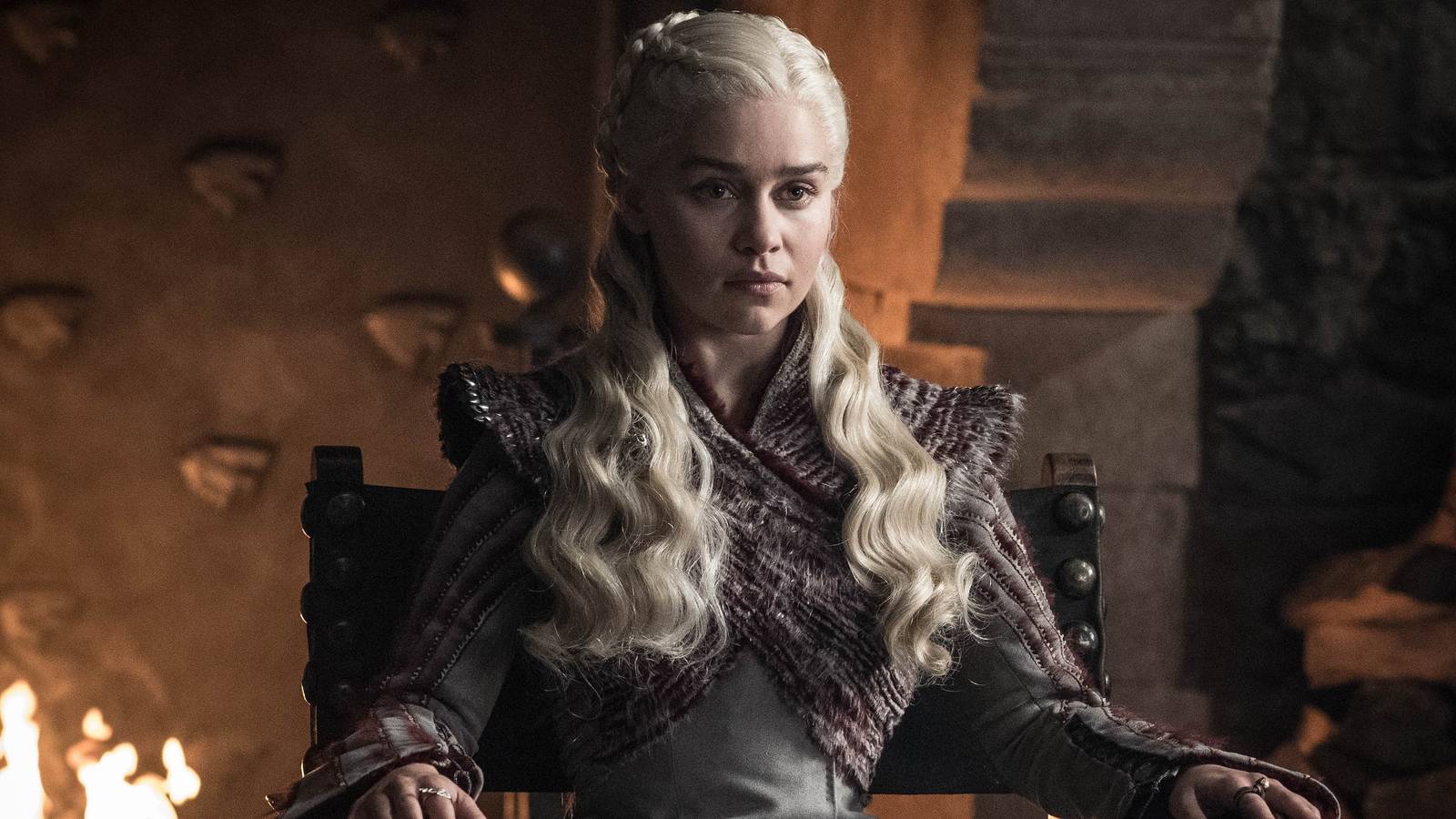Game of Thrones - Daenerys sitting in a chair with a fireplace behind her