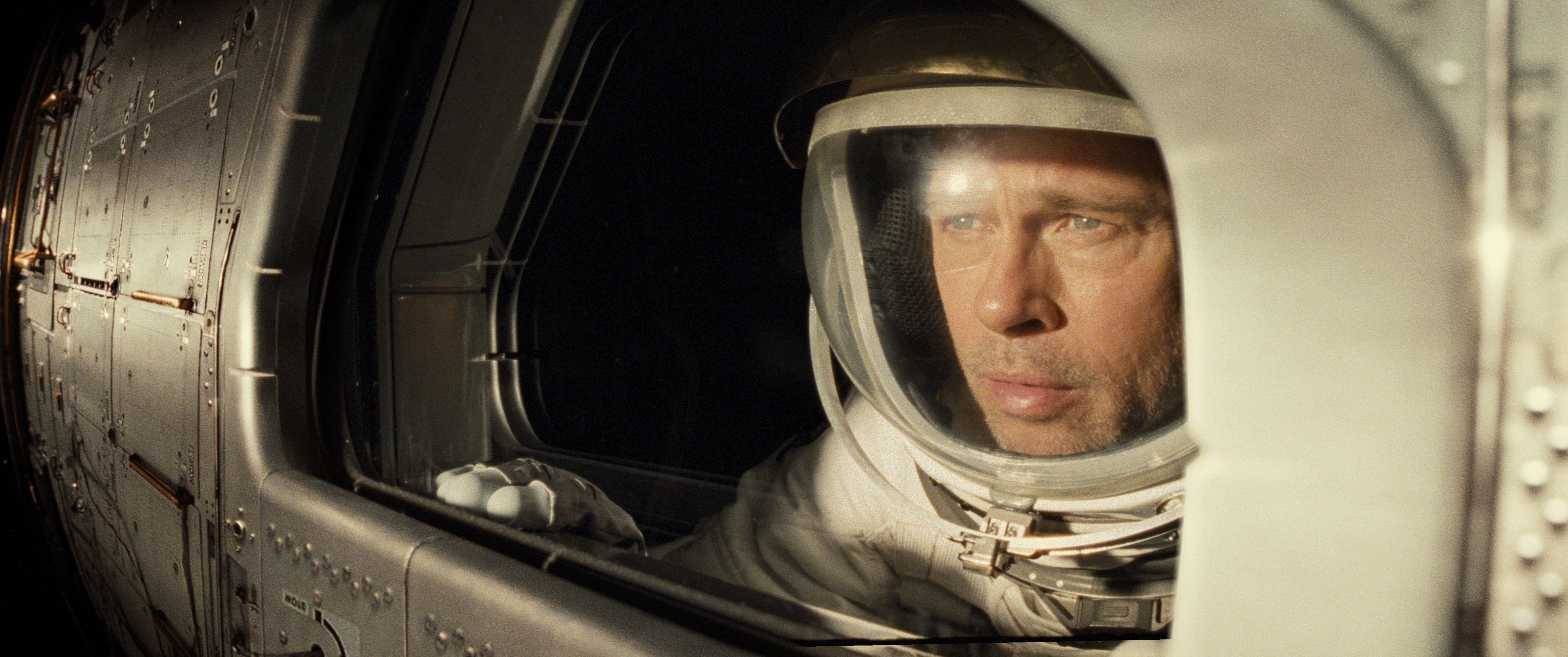 brad pitt’s roy wears a space suit and watches out a window as his shuttle passes the sun in Ad Astra