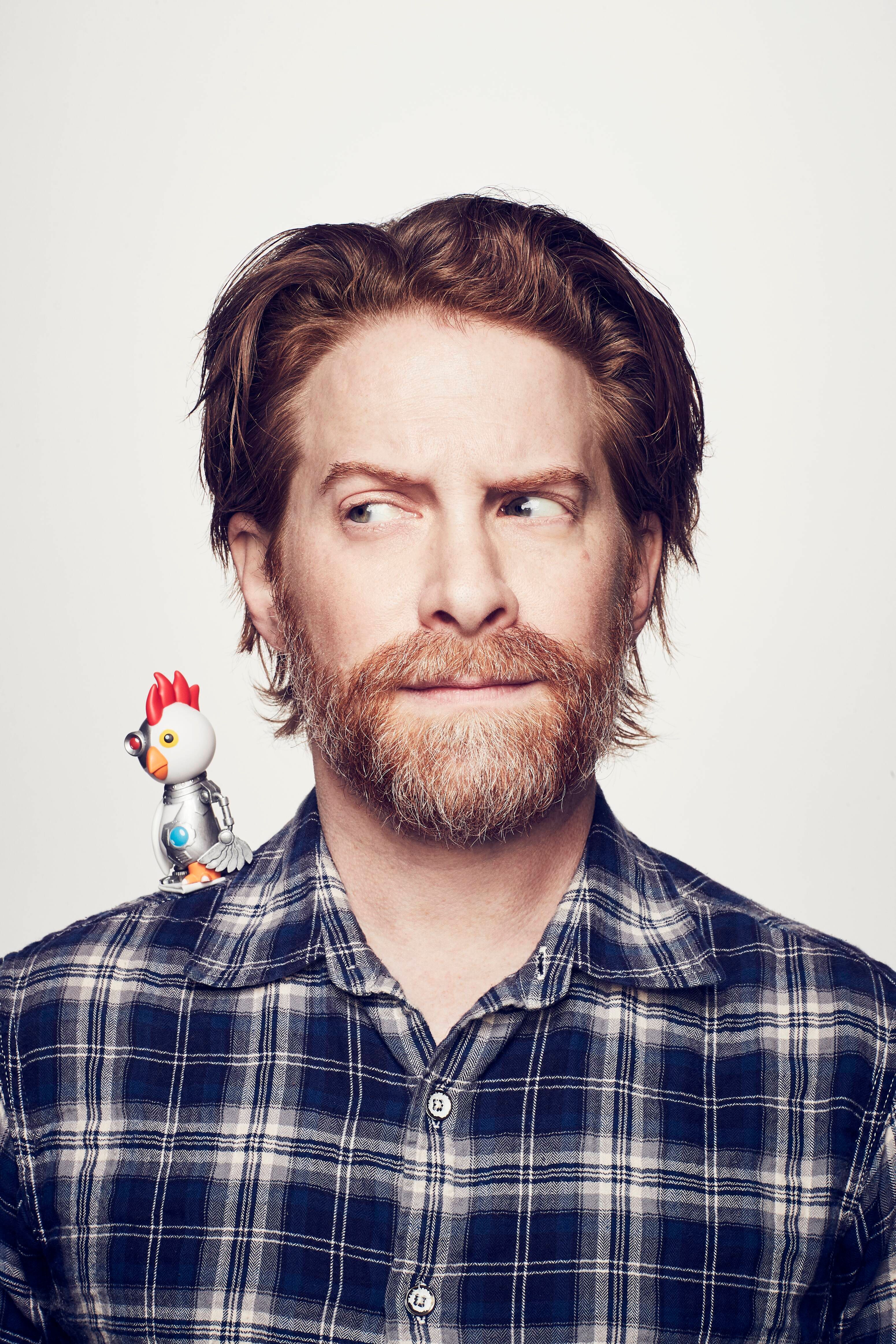 the robot chicken from robot chicken sits on the right shoulder of seth green, who is wary