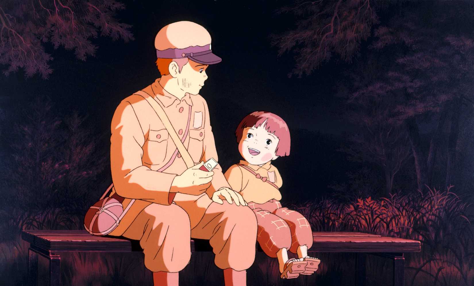 A young Japanese boy and his younger sister sit on a bench together in Grave of the Fireflies