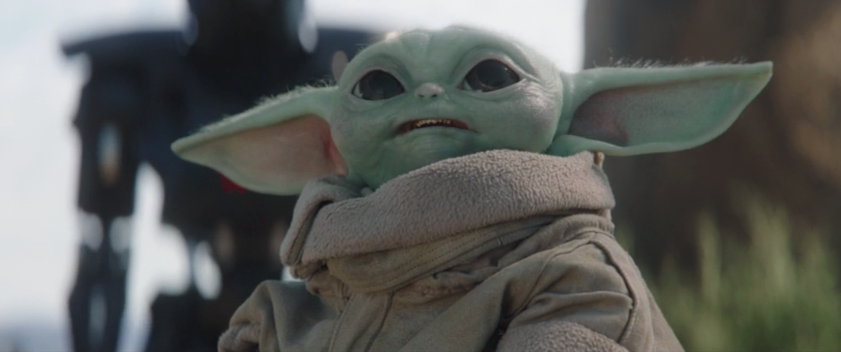Grogu aka Baby Yoda looks up at an Imperial adversary in The Mandalorian