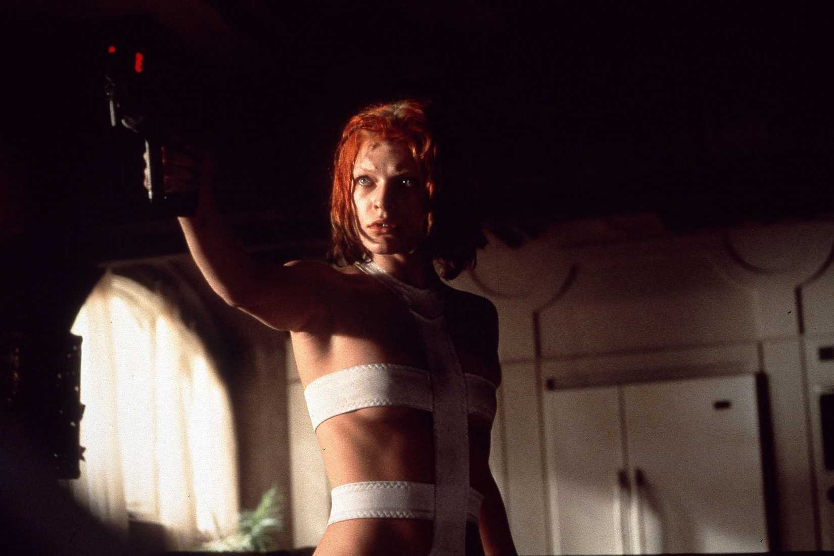 Milla Jovovich in The Fifth Element wearing her white body suit and holding a gun