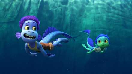 two sea monsters swim in the water. one is blue in color, the one in the back is green. they have scaly skin and fins for ears and long tails