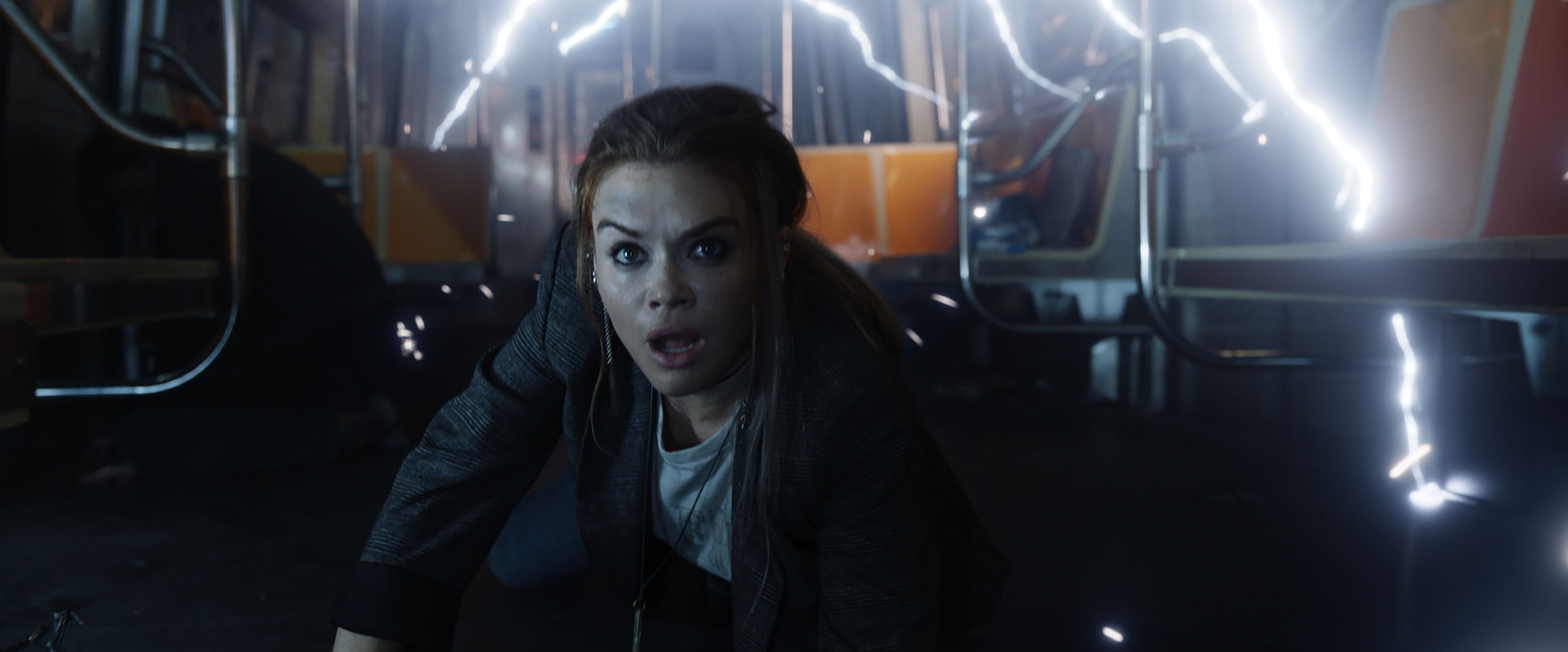 A young brunette-haired woman hits the floor of a subway as tesla coil electricity goes off in Escape Room 2