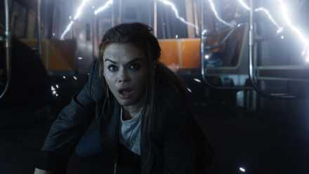 A young brunette-haired woman hits the floor of a subway as tesla coil electricity goes off in Escape Room 2