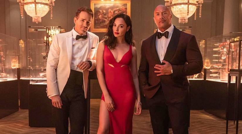 Ryan Reynolds, Gal Gadot, and Dwayne Johnson wearing formal attire in Red Notice