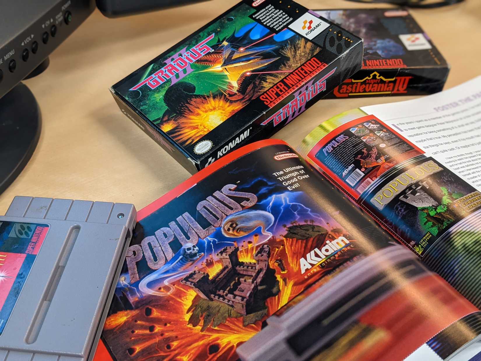 A book about Super NES games is opened to the Populous page. 