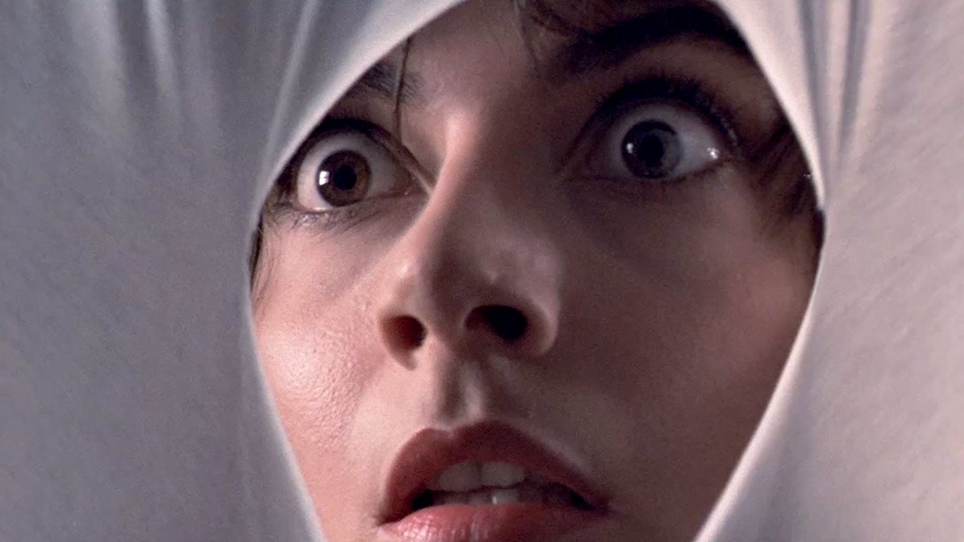  A woman looks through a white cloth