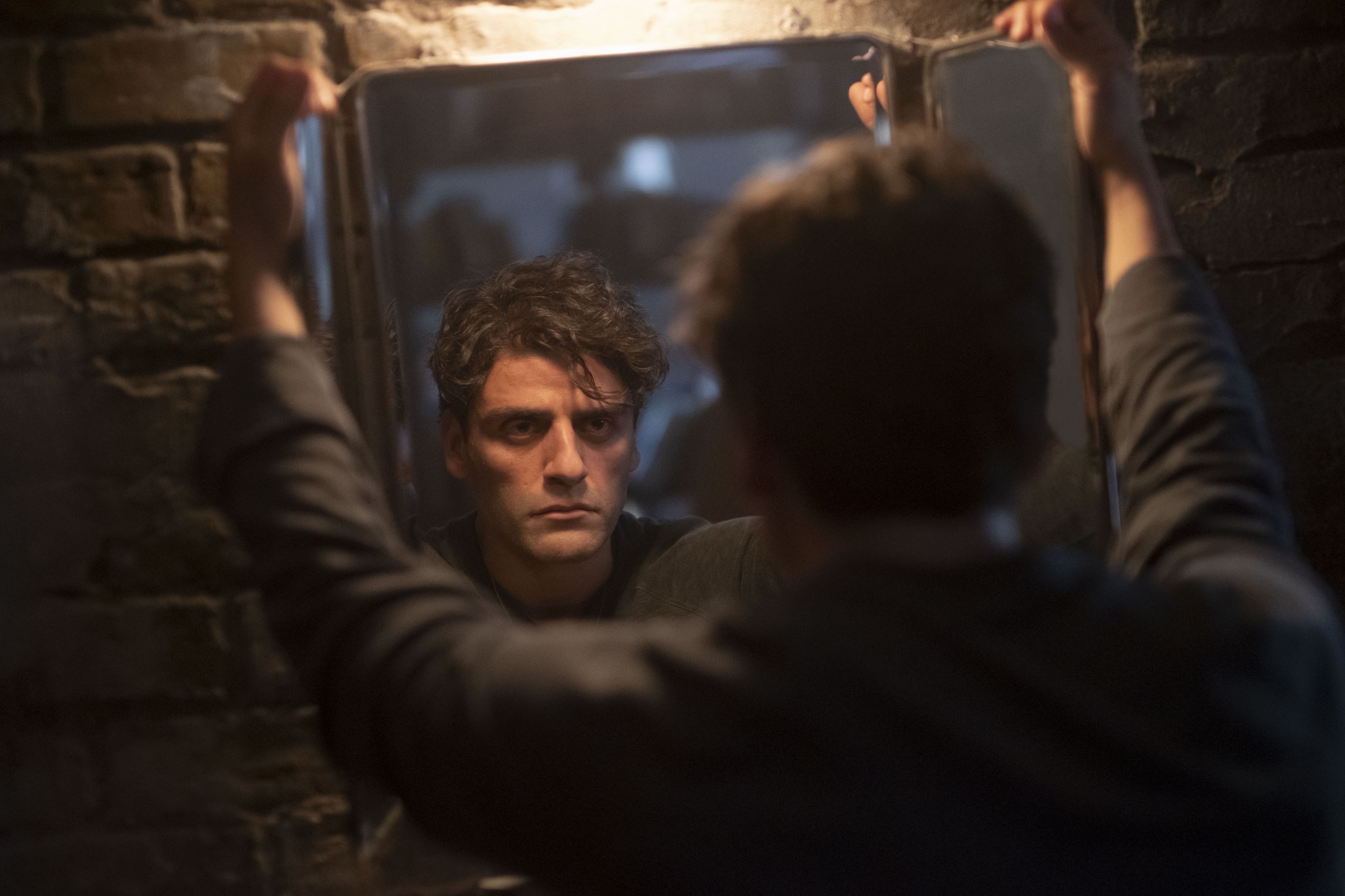Steven Grant/Marc Spector stares into a mirror, disillusioned in the Disney Plus series Moon Knight