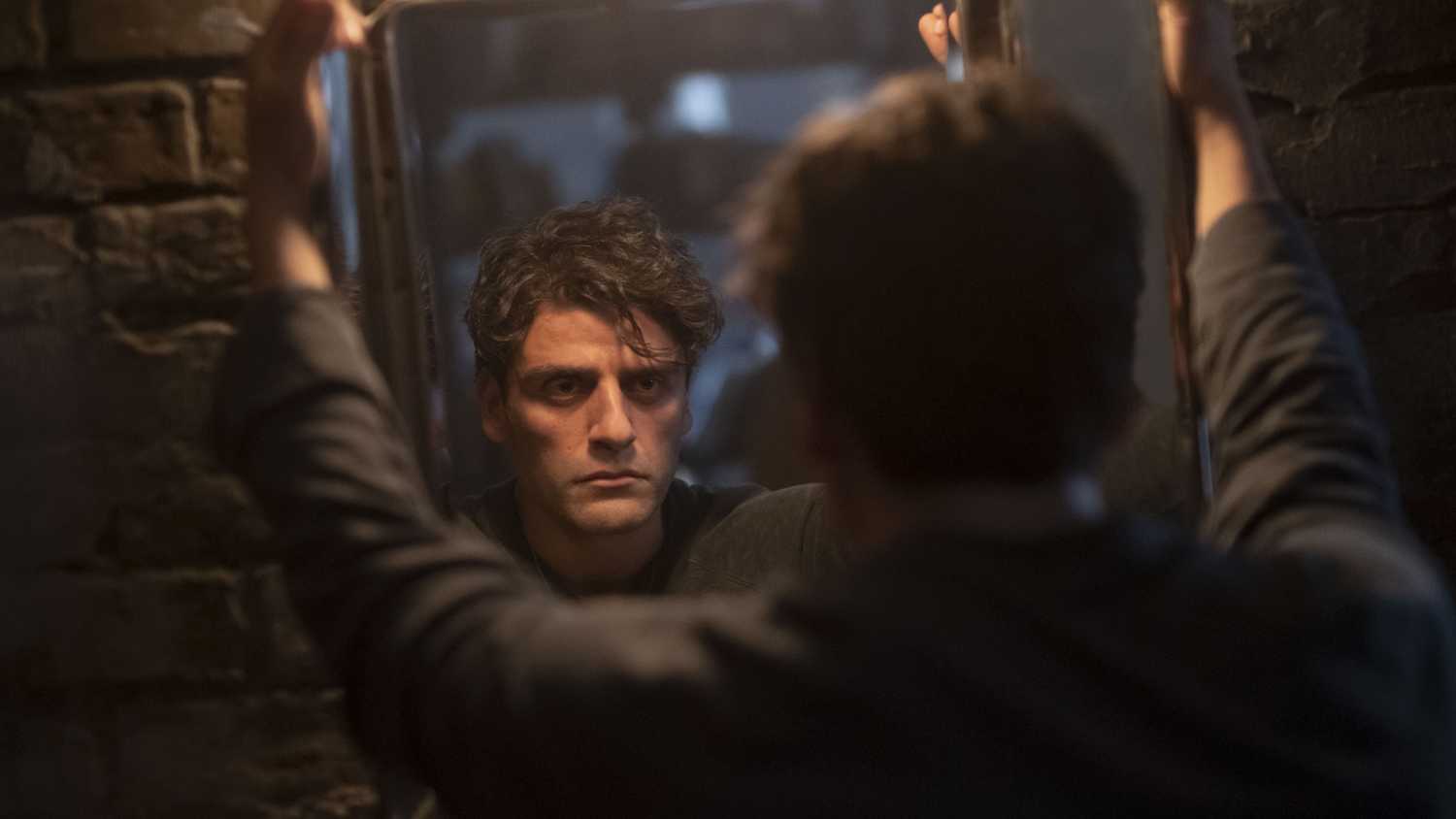 Steven Grant/Marc Spector stares into a mirror, disillusioned in the Disney Plus series Moon Knight