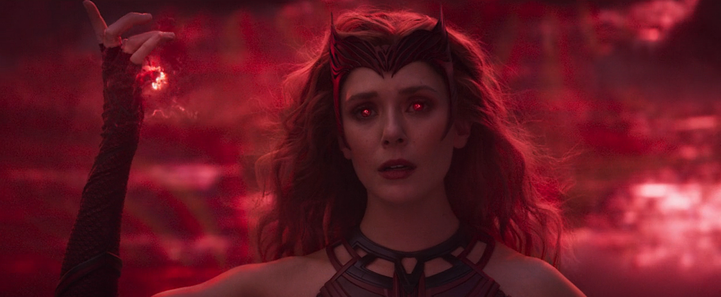 Elizabeth Olsen in WandaVision in full Scarlet Witch mode, with glowy red hands and eyes