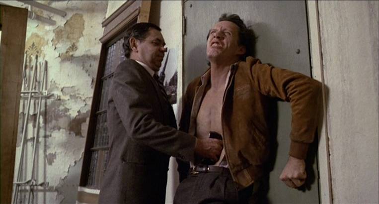 Another man takes a video cassette out of James Woods’s stomach slit in Videodrome