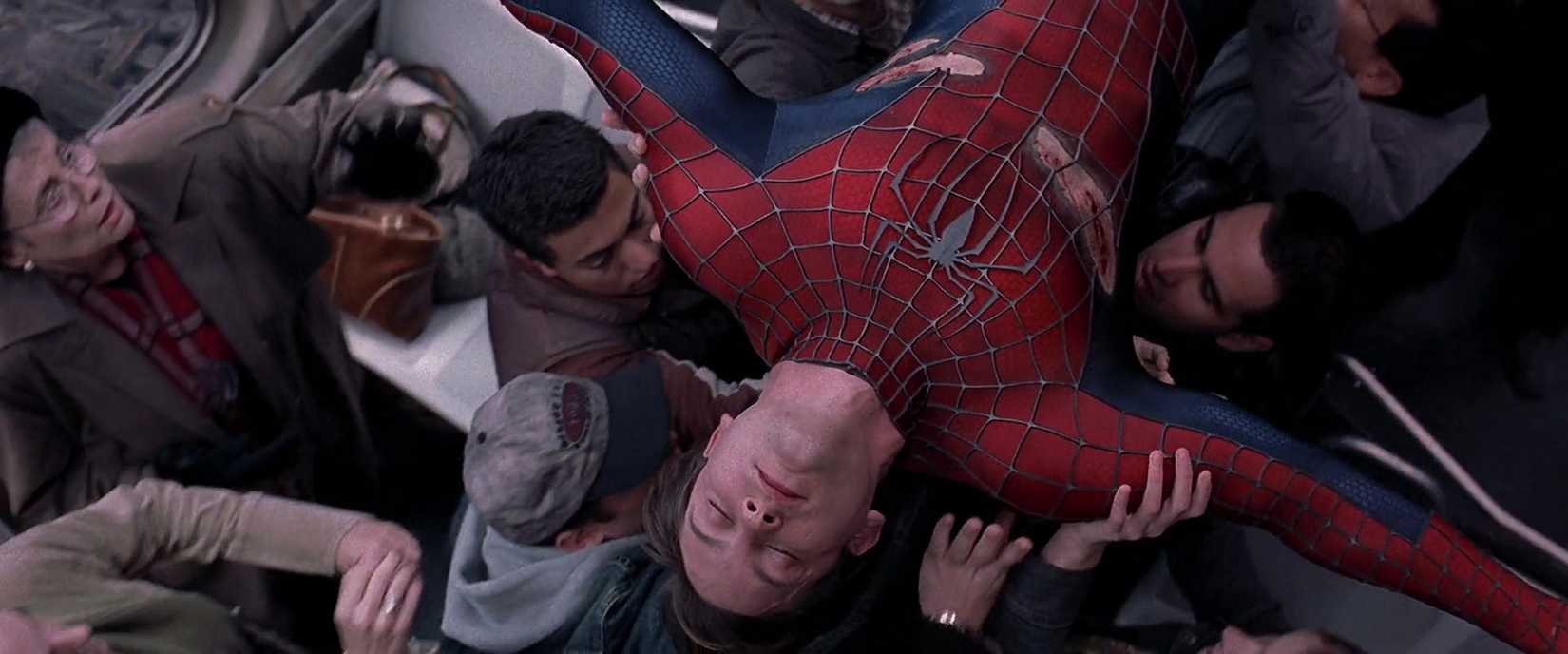 Tobey Maguire’s Spider-Man is carried on a train by passengers in Spider-Man 2.