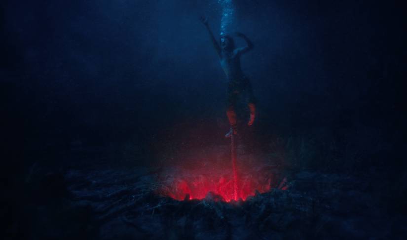 Steve struggles against a vine pulling him into an underwater gate to the Upside Down in Stranger Things