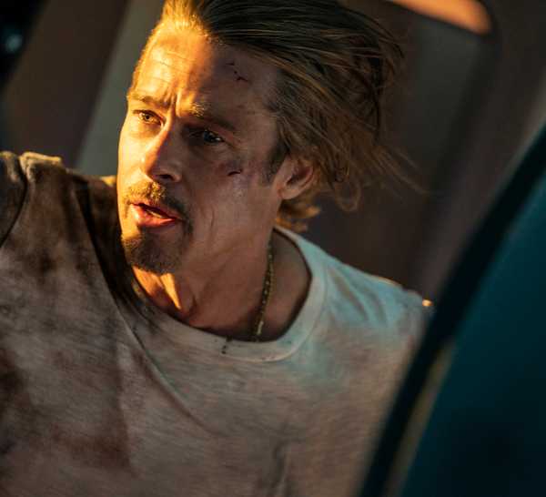Ladybug (Brad Pitt) looking out a train door in Bullet Train
