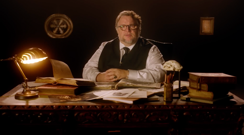 guillermo del toro sits at a desk