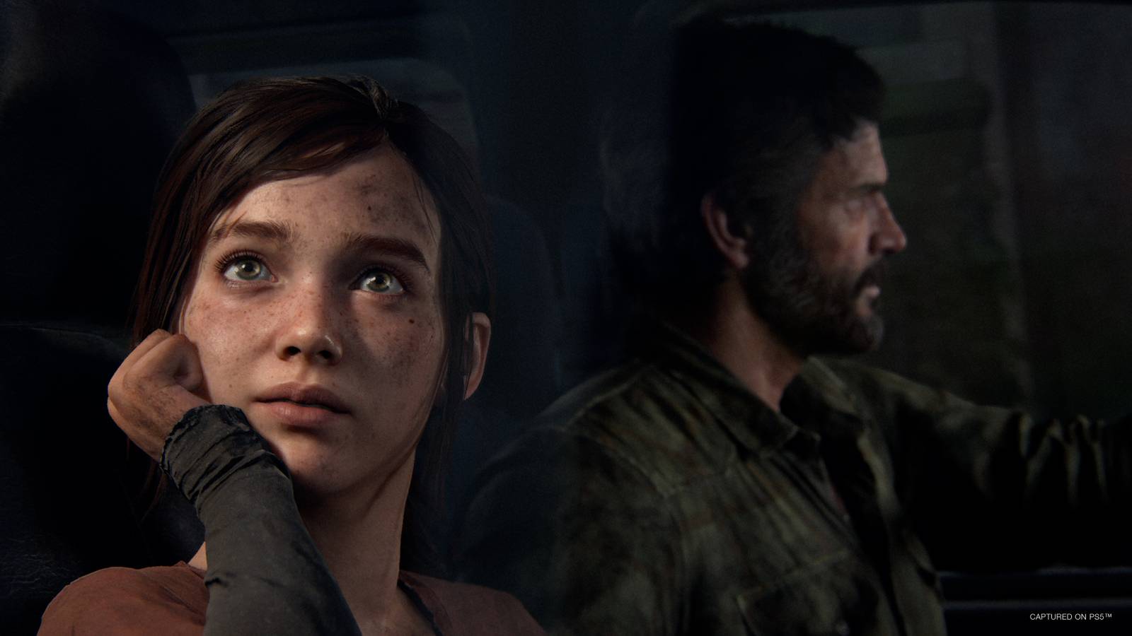 Ellie looks out the window of a truck while Joel drives in a screenshot from The Last of Us Part 1