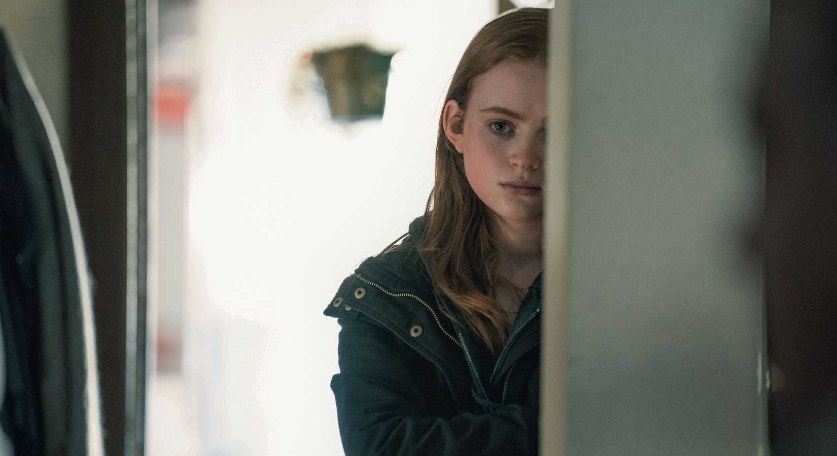 Charlie’s 17-year-old daughter Ellie (Sadie Sink) stands halfway eclipsed by a doorway, looking sad, in The Whale