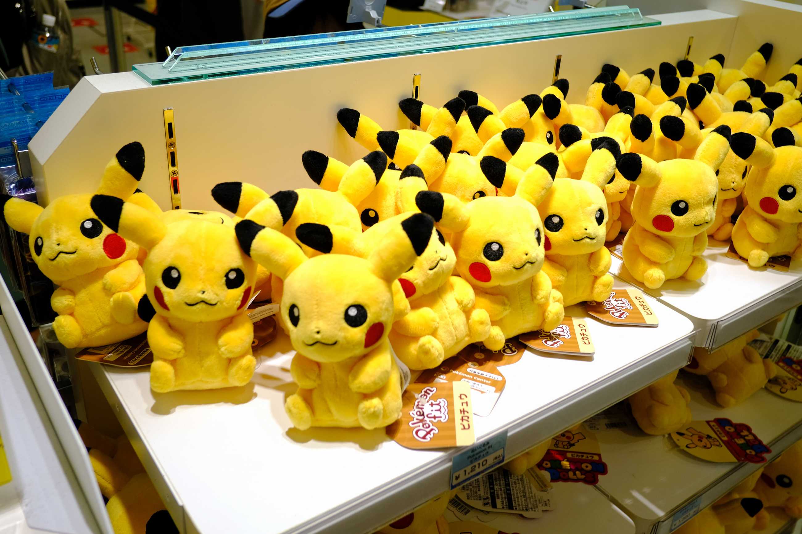 Rows of Pikachu plushies on a shelf in a Tokyo retail store