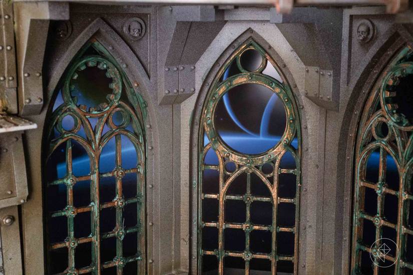 Looking through the ruined windows of a gothic spacecraft, you can see in the distance two moons rising over the rim of a dark planet.